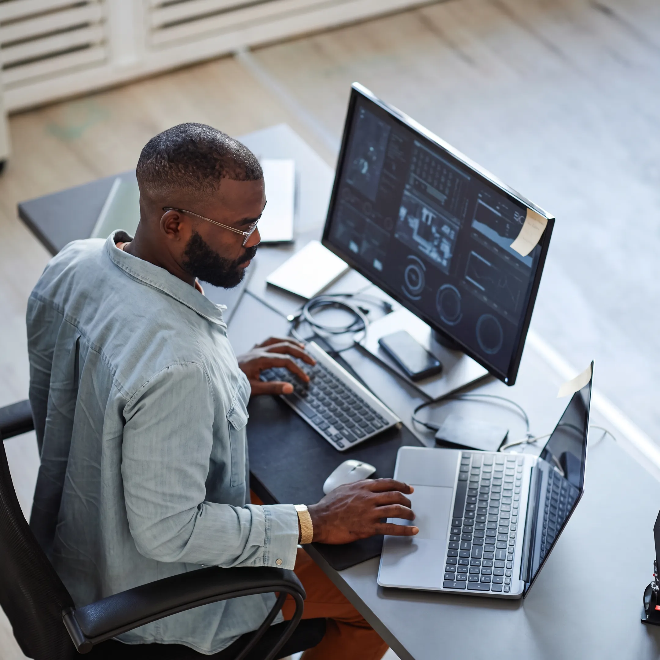 Security operations team monitoring business systems on multiple screens