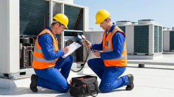 HVAC technician performing commercial rooftop unit inspection and preventive maintenance service