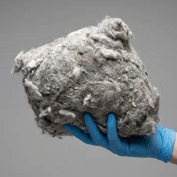 Close-up of dangerous lint buildup being removed from dryer vent system