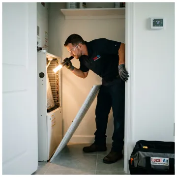 Technician inspecting an indoor AC system