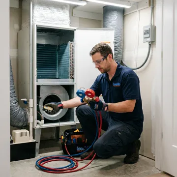 Technician inspecting HVAC equipment during repair visit