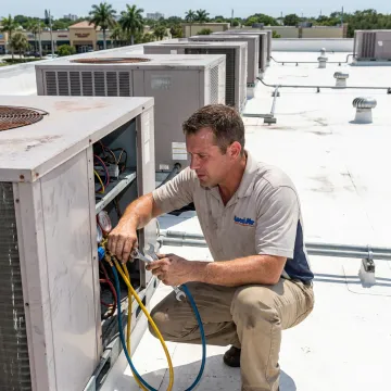 Technician servicing commercial air conditioning equipment