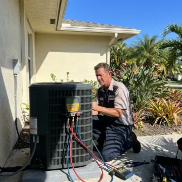 Residential HVAC technician servicing an air conditioning unit
