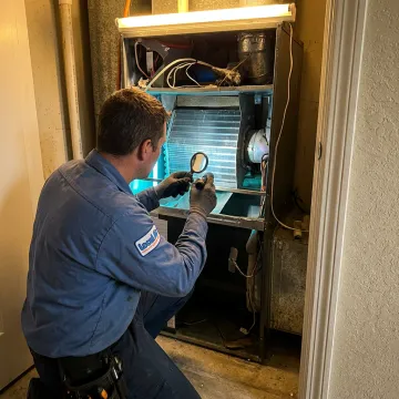 HVAC technician inspecting an air handler