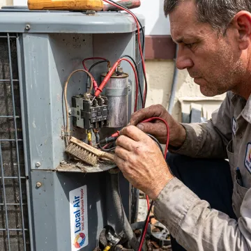 Technician checking AC components during maintenance