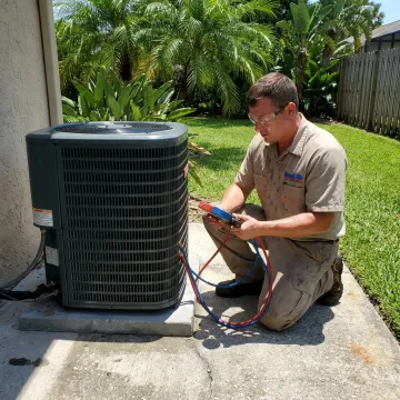 Technician servicing a residential air conditioning unit