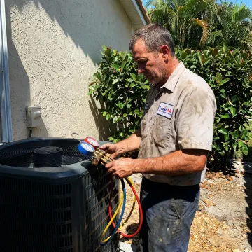 HVAC technician repairing a home air conditioning system