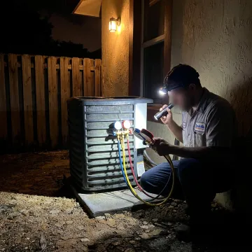 Technician repairing an emergency AC issue
