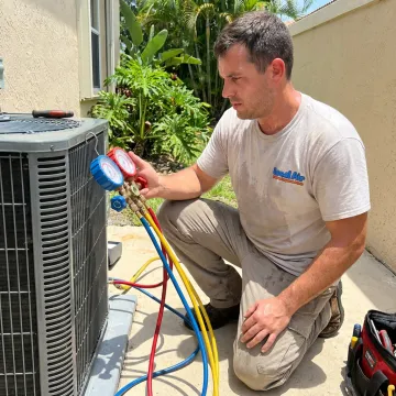 HVAC technician testing AC refrigerant pressure