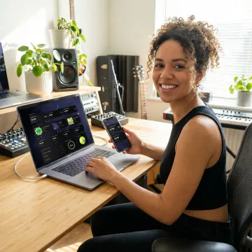 Artist reviewing streaming analytics on multiple devices showing global music performance