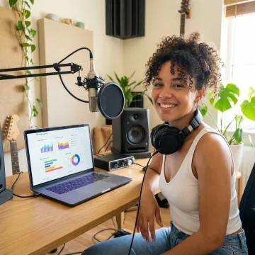 Music artist using laptop with streaming analytics and digital marketing dashboard