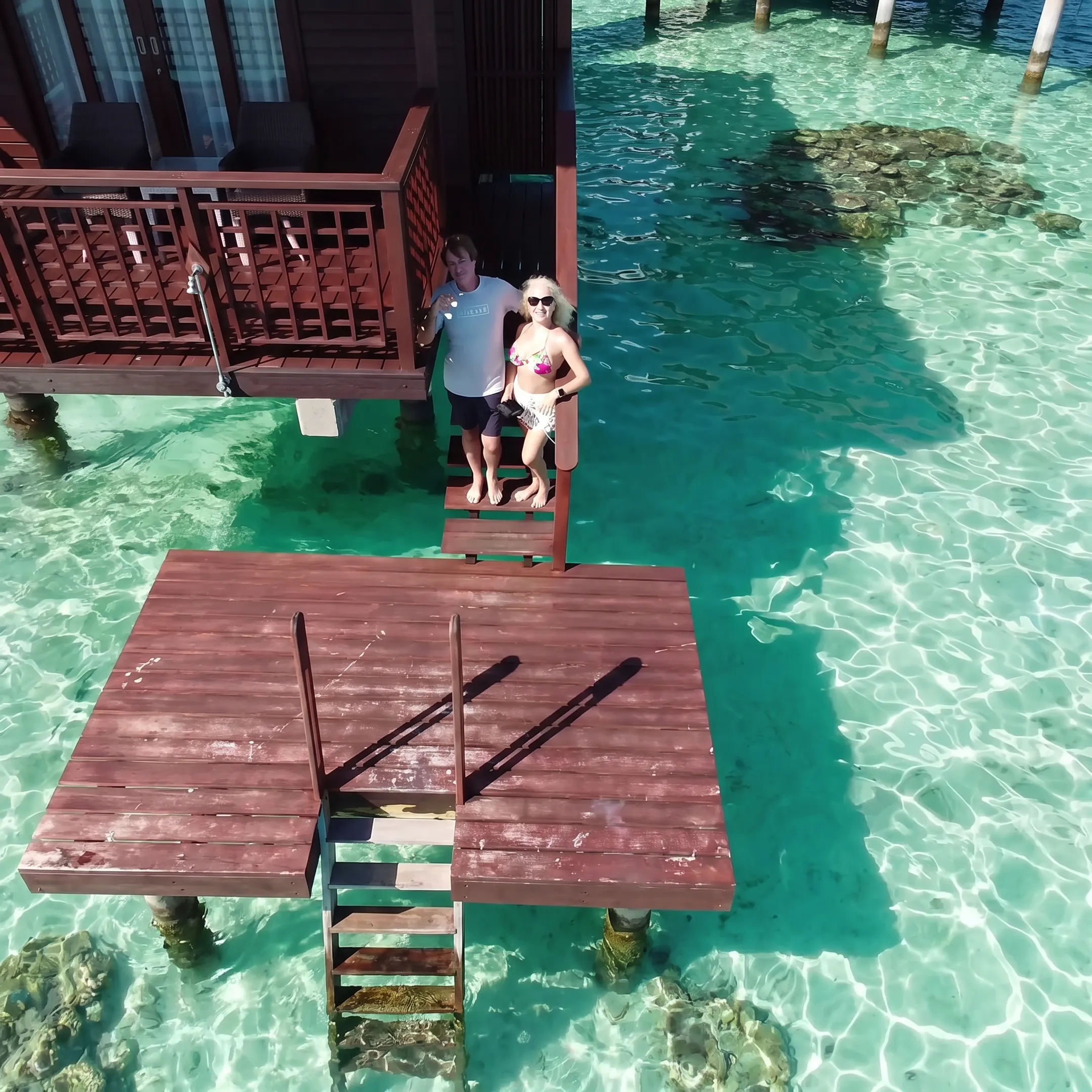 Traveler relaxing on a Bora Bora overwater bungalow deck