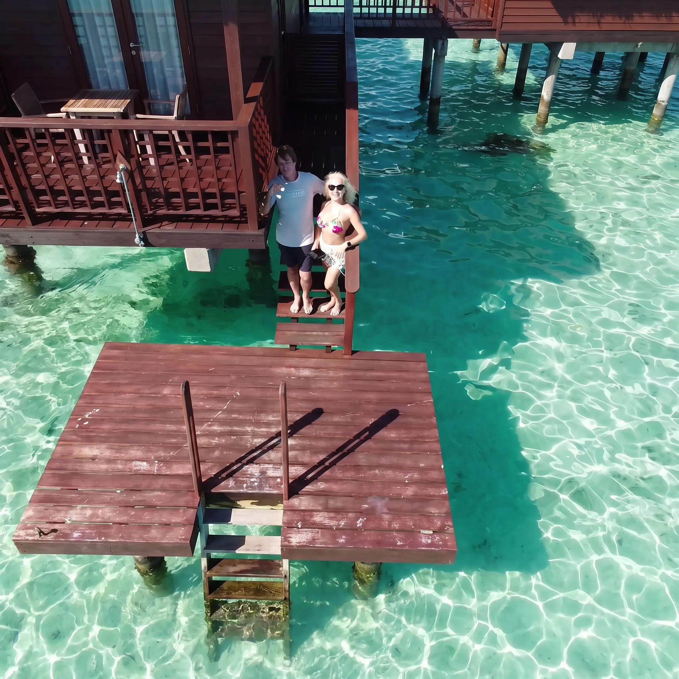 Traveler enjoying an overwater bungalow deck above a French Polynesian lagoon
