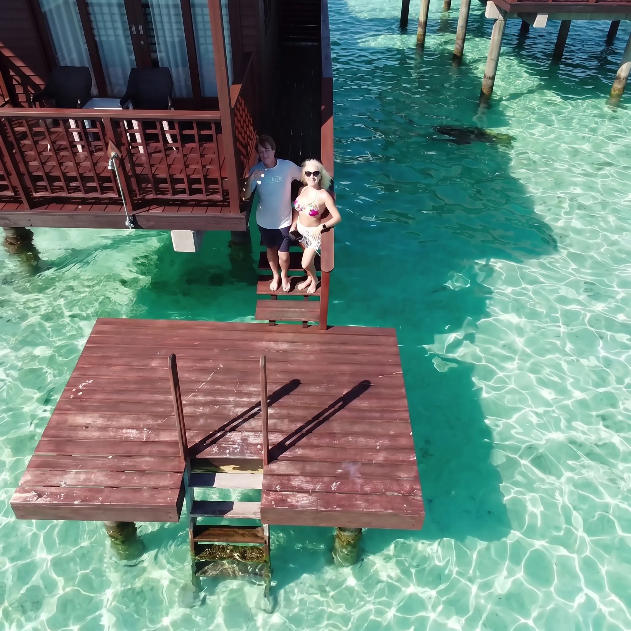 Couple enjoying a romantic sunset from a Bora Bora overwater bungalow