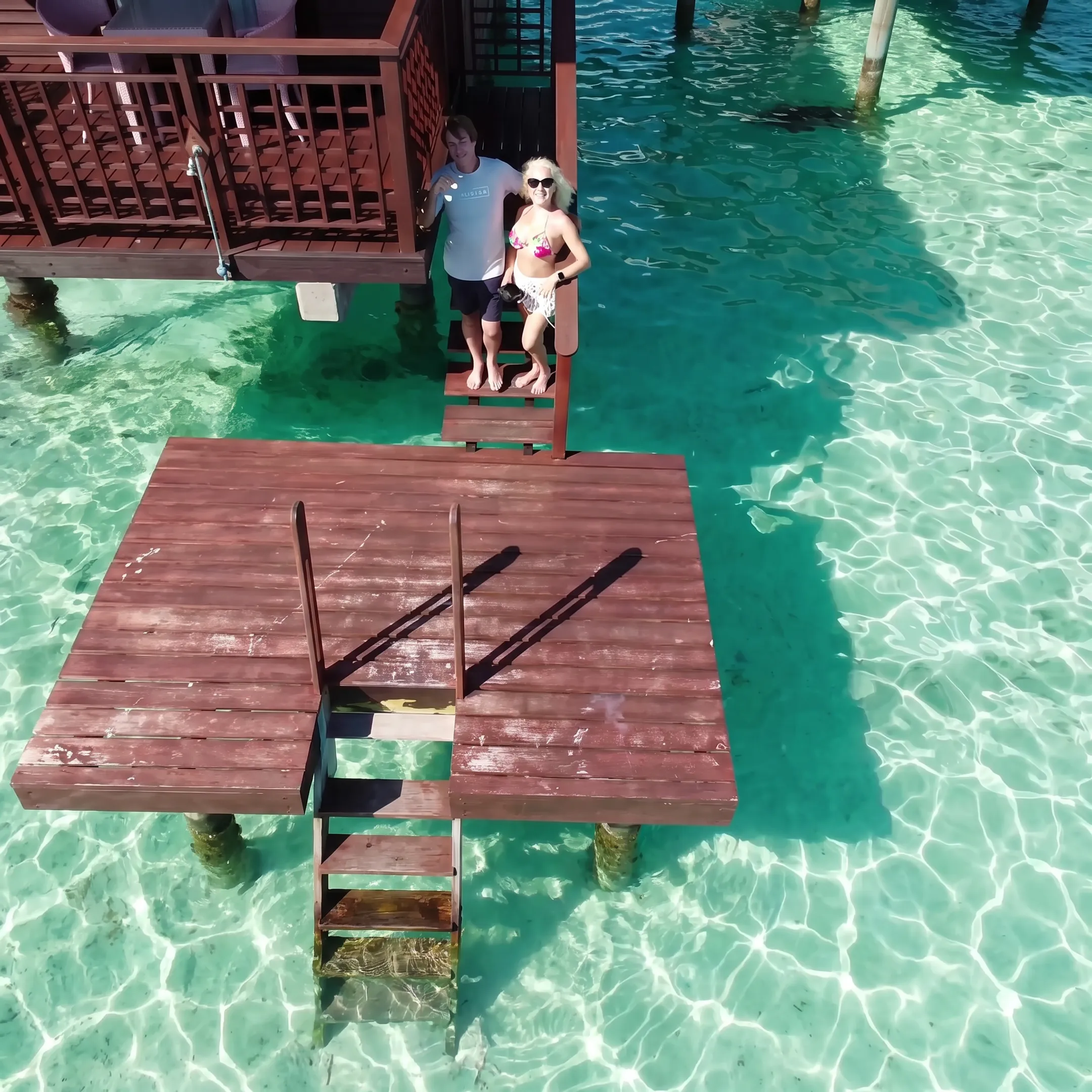 Travelers enjoying an overwater bungalow and turquoise lagoon in French Polynesia