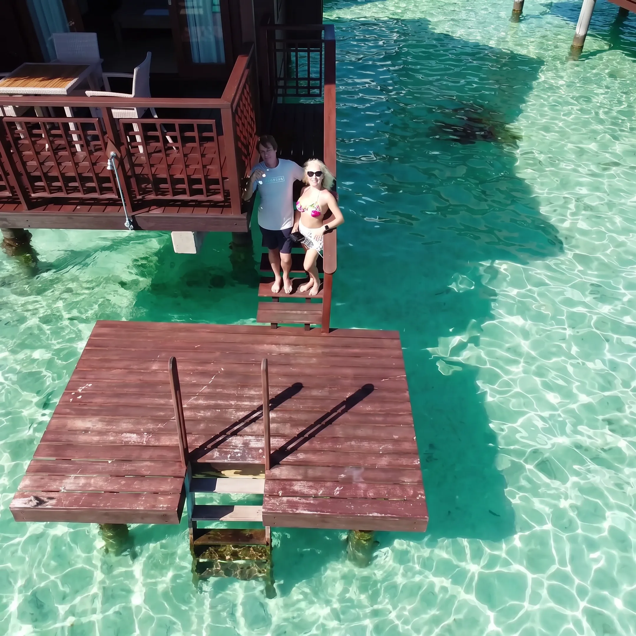 Traveler relaxing on a private overwater bungalow deck overlooking Moorea's lagoon