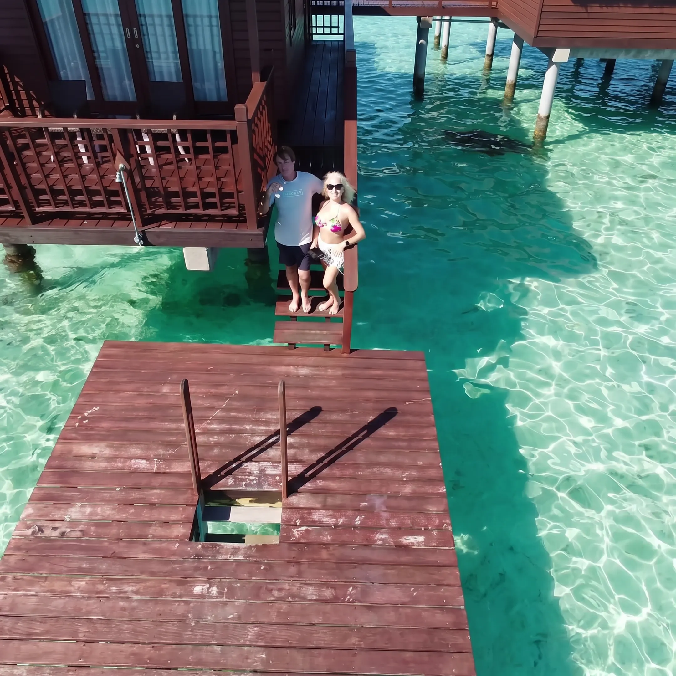 Couple enjoying a sunset from a Bora Bora overwater bungalow