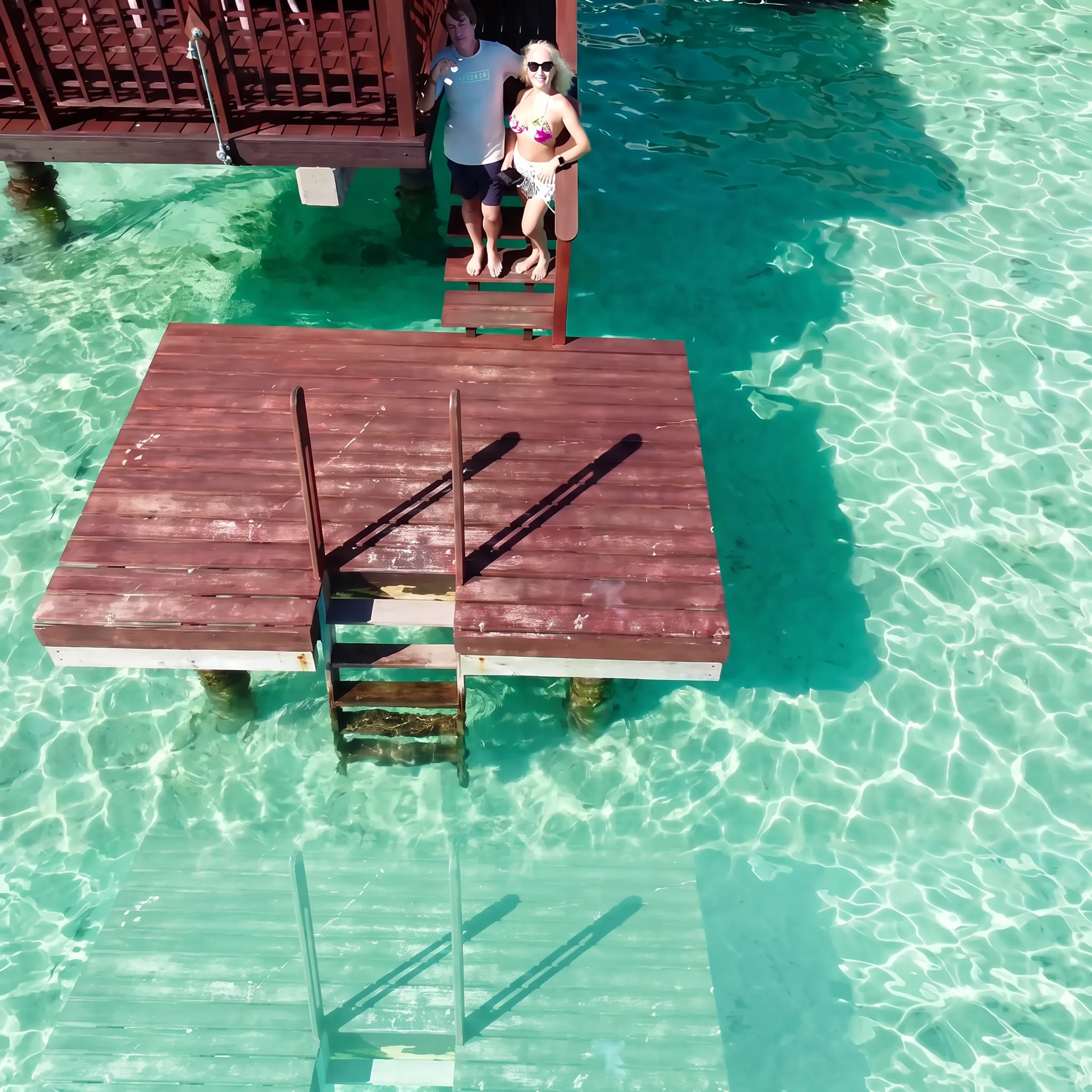 Couple enjoying a French Polynesia honeymoon from an overwater bungalow