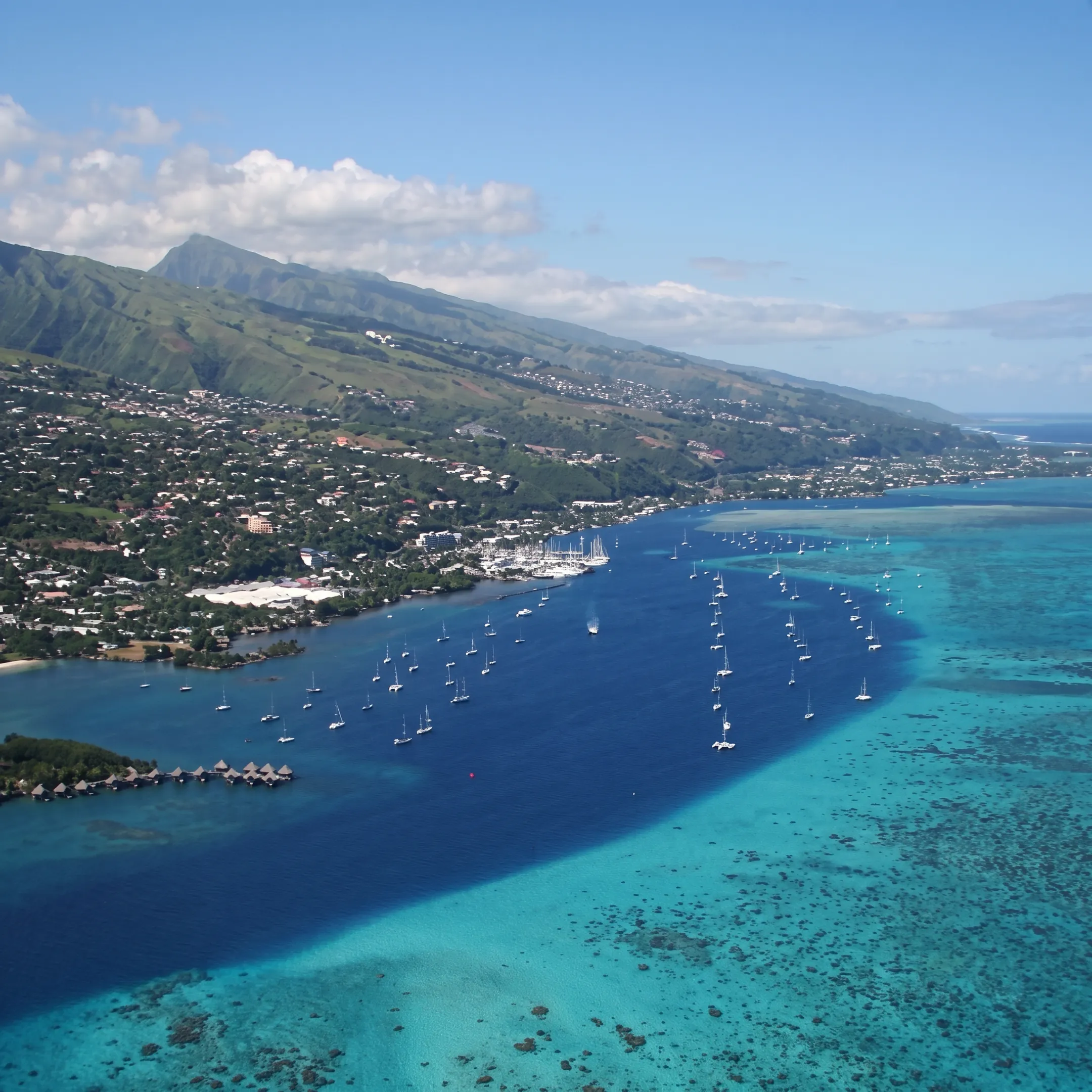 Small luxury cruise ship sailing through a turquoise South Pacific lagoon