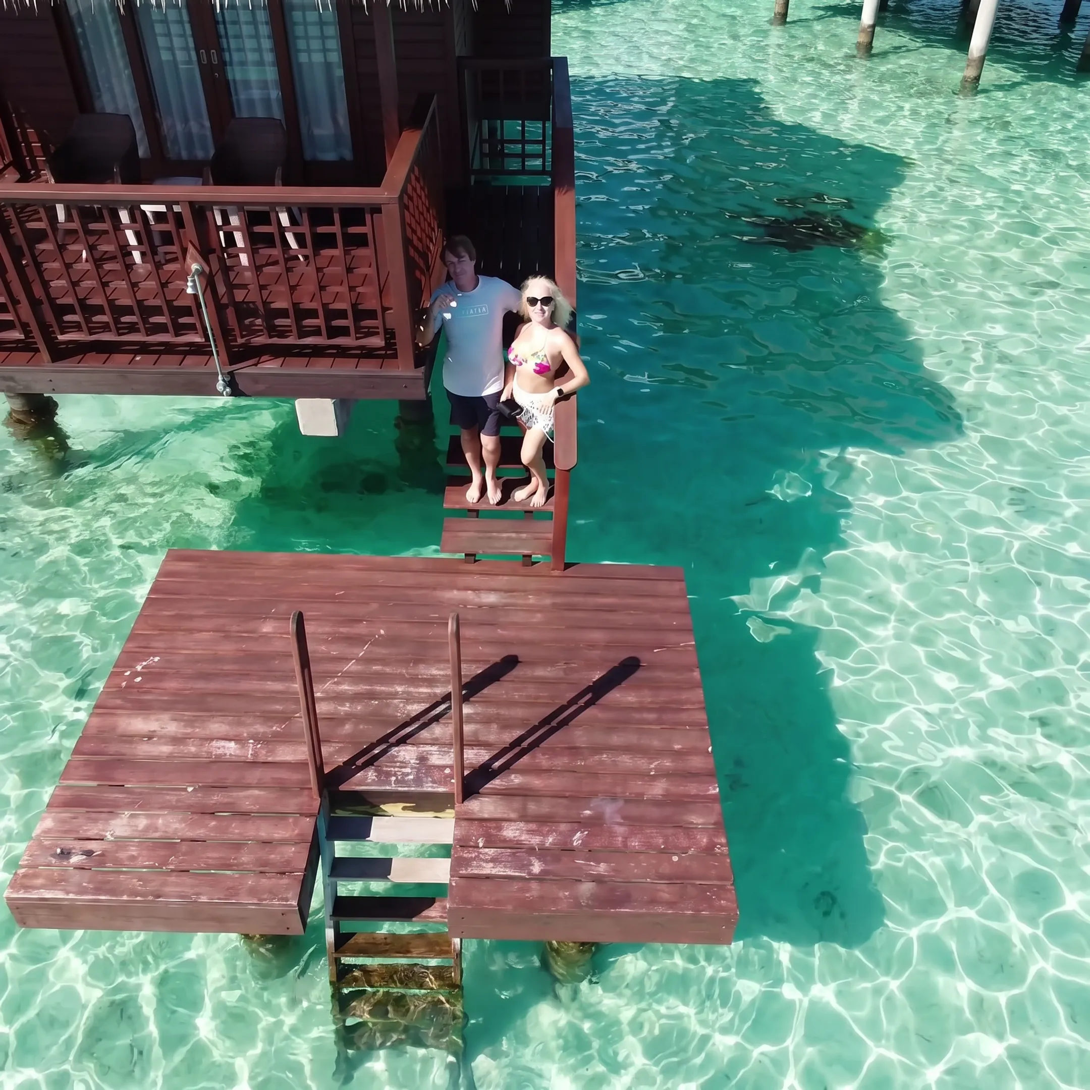 Couple relaxing on a Bora Bora overwater bungalow deck