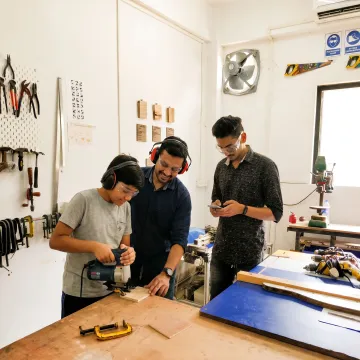 Student learning woodworking tools in a makerspace