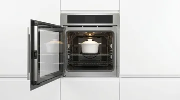 Side-swing oven door open more than 100 degrees showing ergonomic front access design