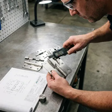 Engineer inspecting stainless steel hinge components