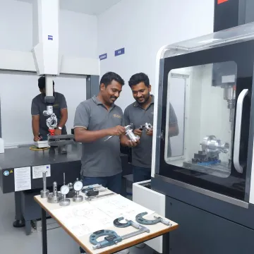 Engineers reviewing machined components in a manufacturing facility