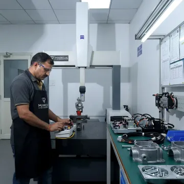 Technician inspecting machined parts and assembled modules