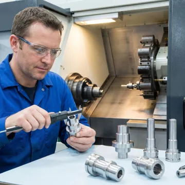 Machinist inspecting precision turned parts