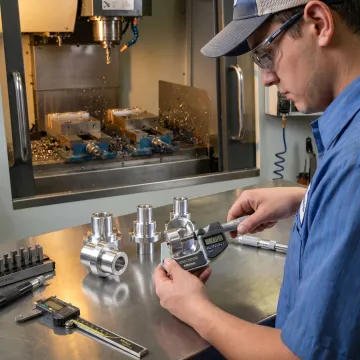 Technician inspecting precision turned parts
