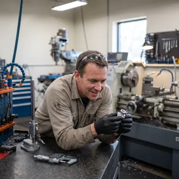 Technician inspecting machined aerospace part