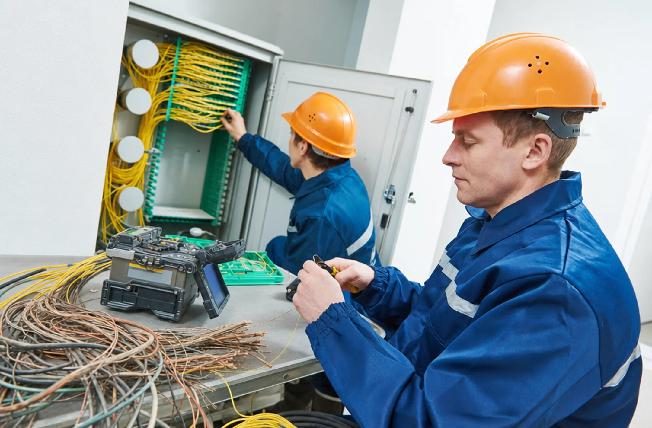 Telecom technician installing fiber optic cable replacing old copper wiring