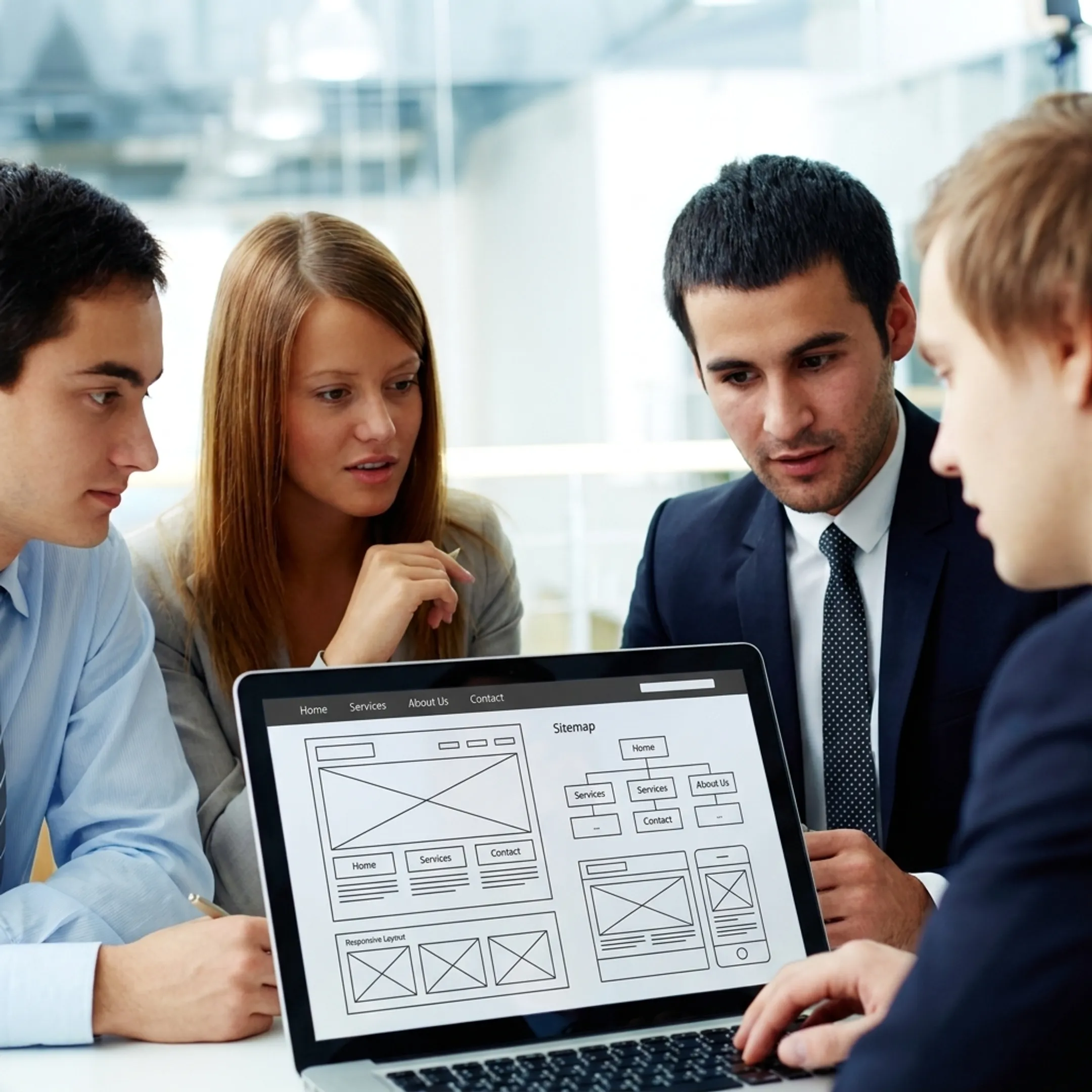 Team planning website redesign on a laptop