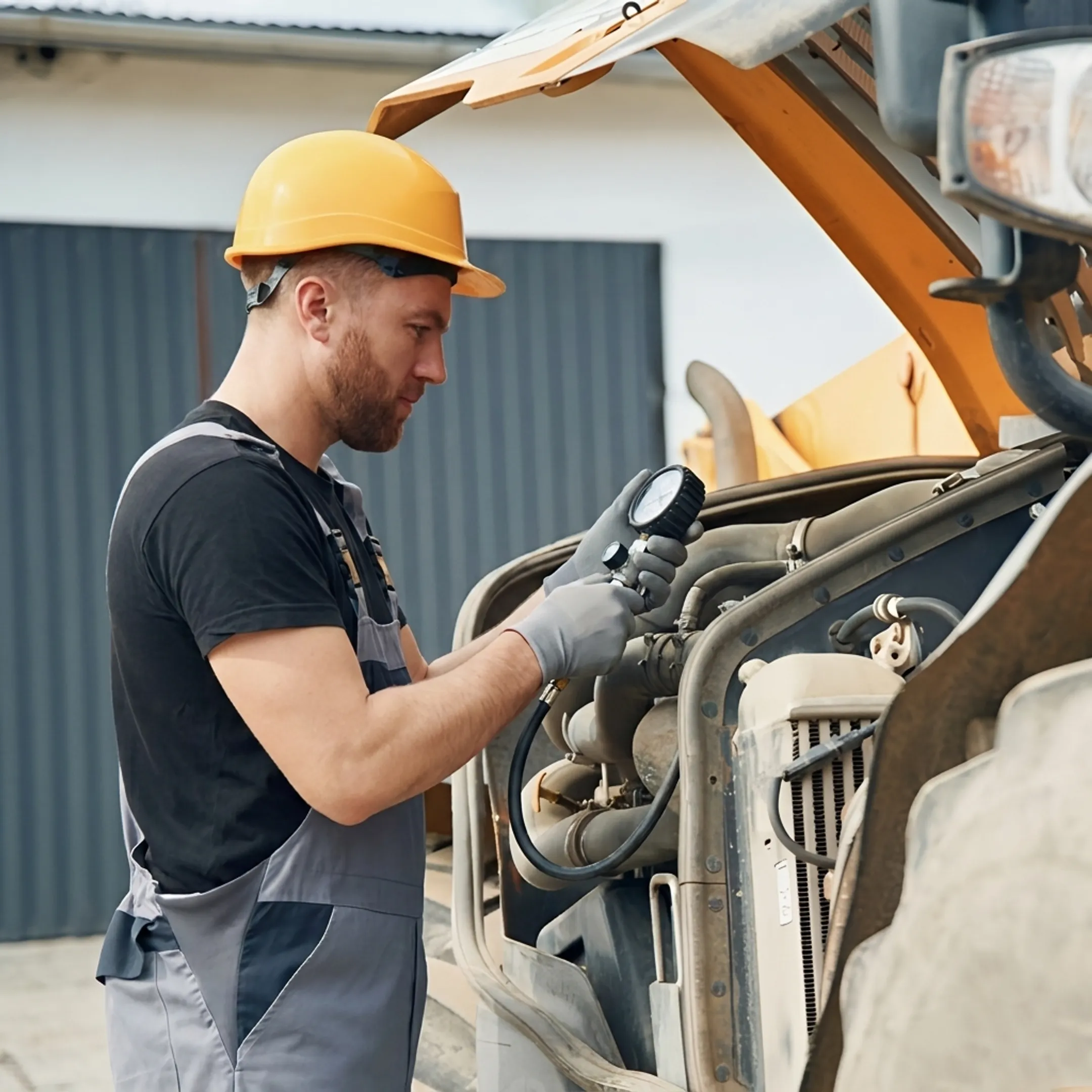 Technician diagnosing hydraulic equipment at a construction jobsite