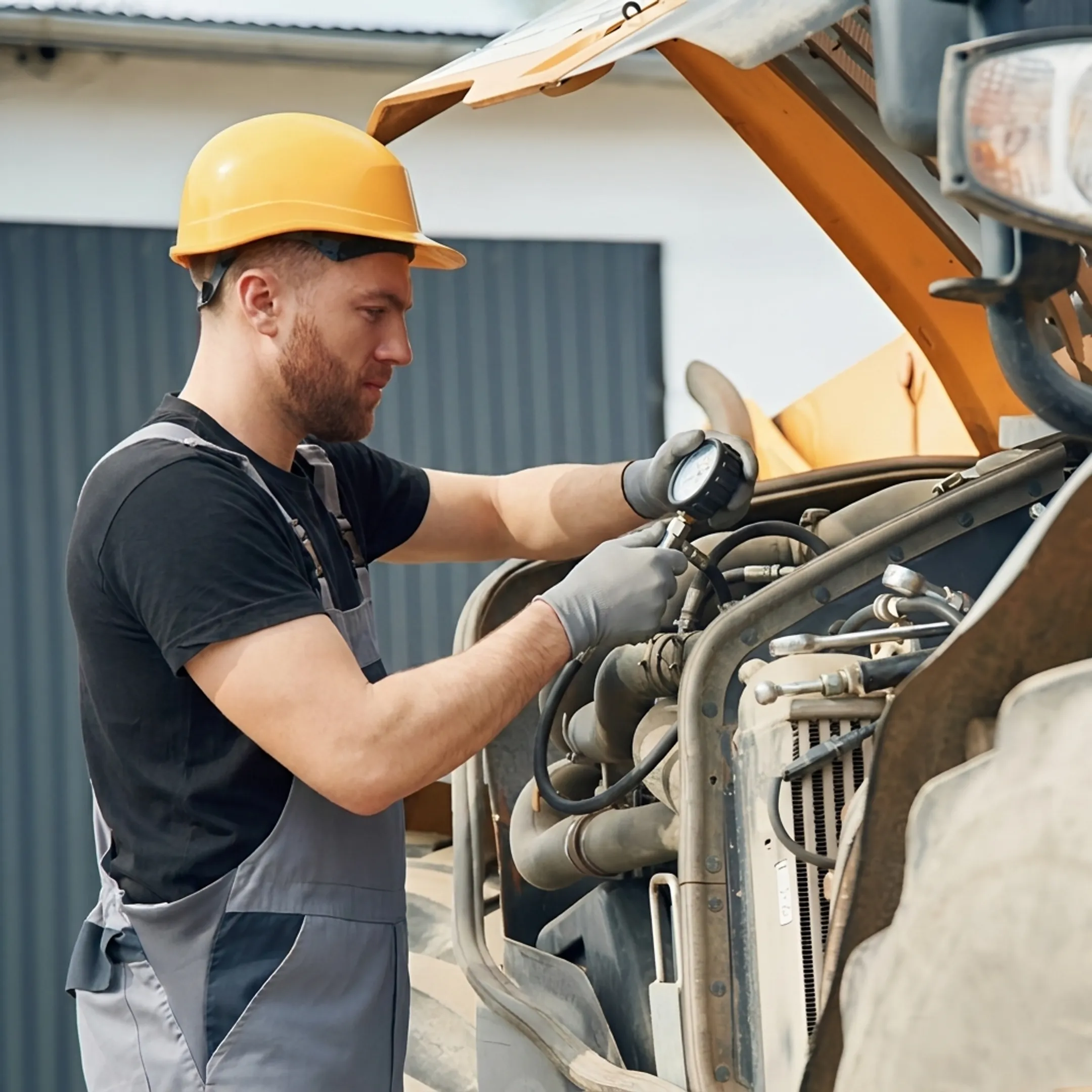 Technician diagnosing a hydraulic cylinder on construction equipment