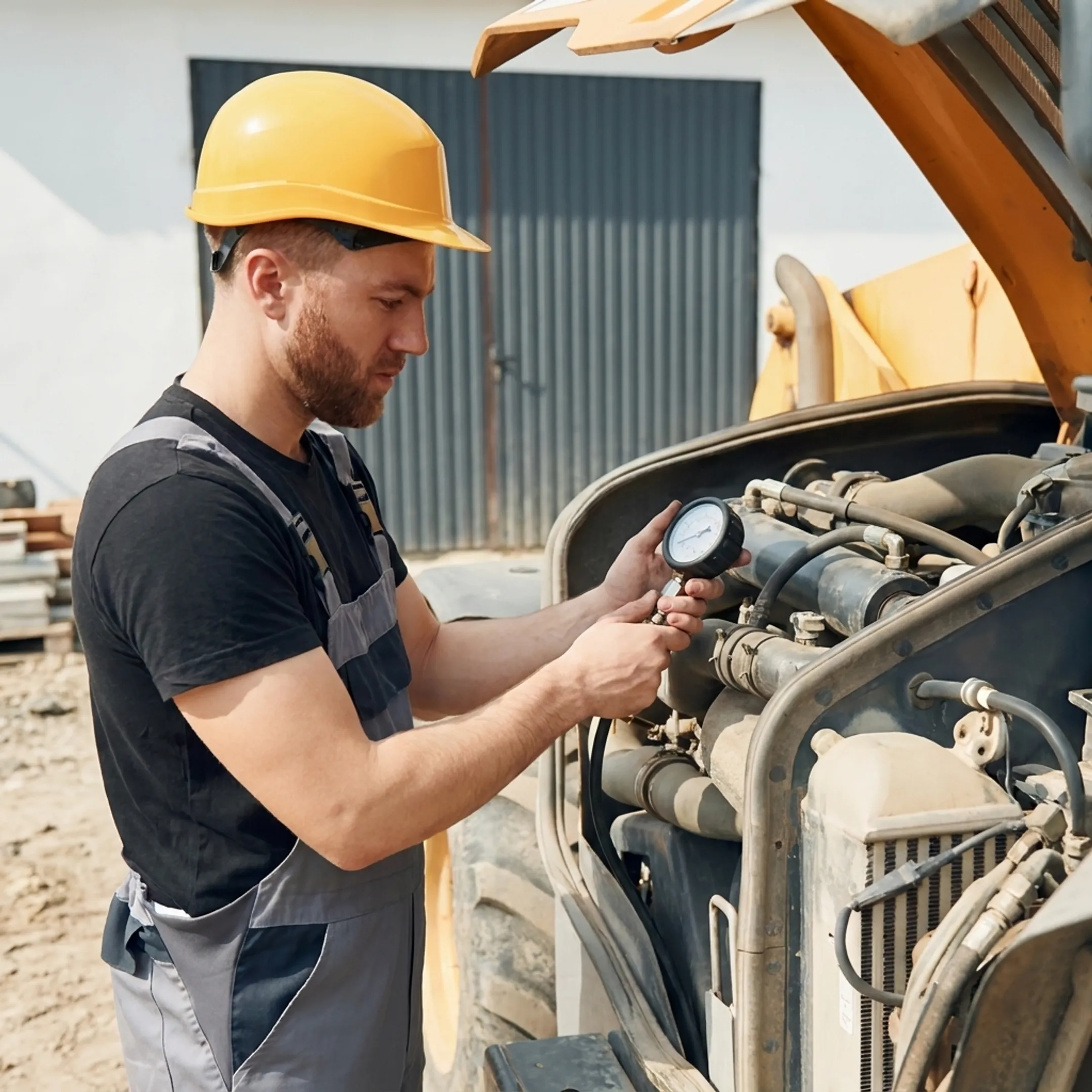 Technician diagnosing a hydraulic cylinder on construction equipment