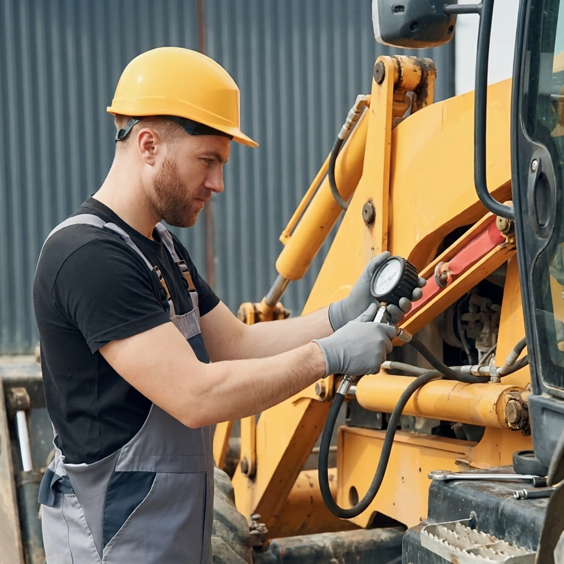 Technician diagnosing a hydraulic cylinder on heavy equipment