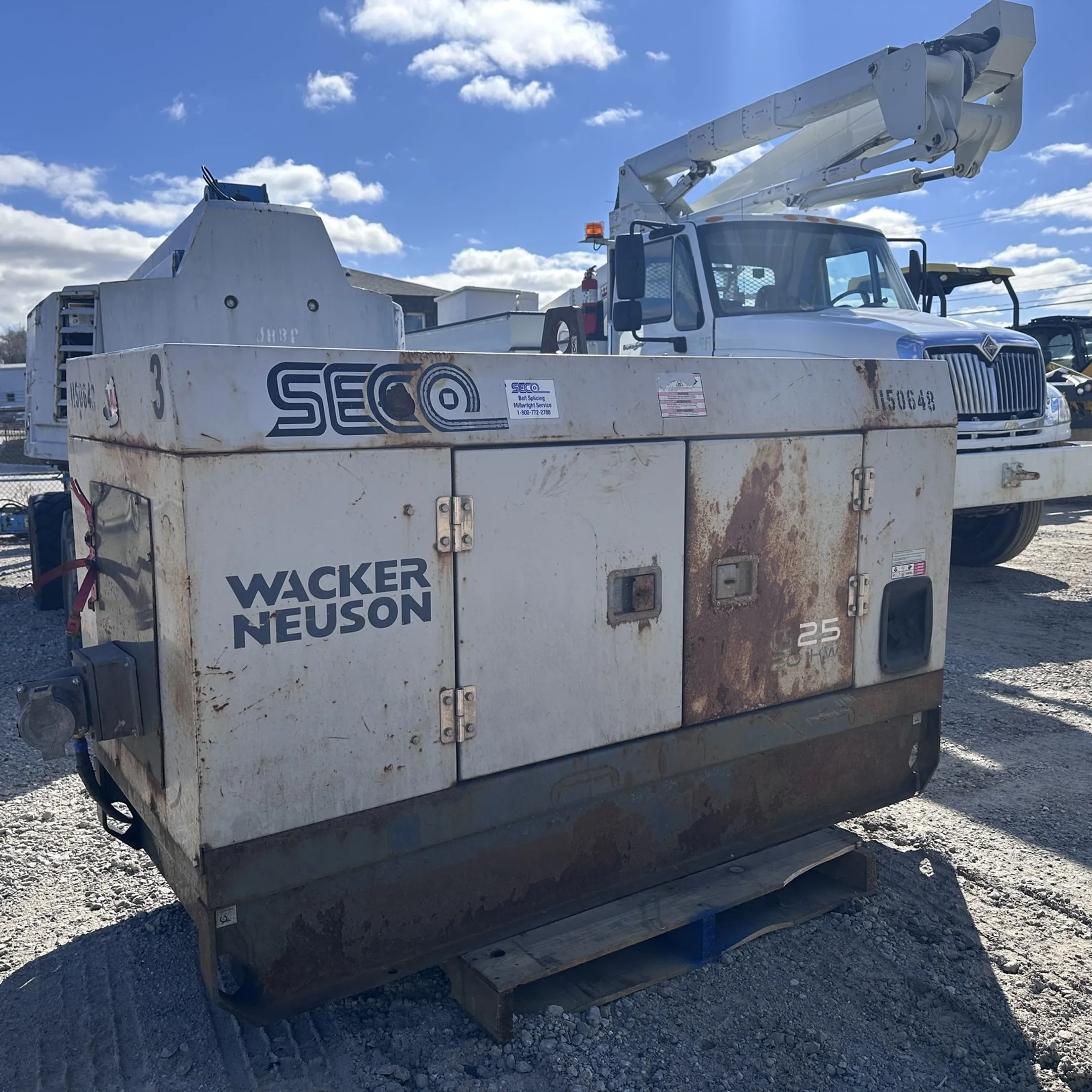 Technician diagnosing an engine beside construction equipment