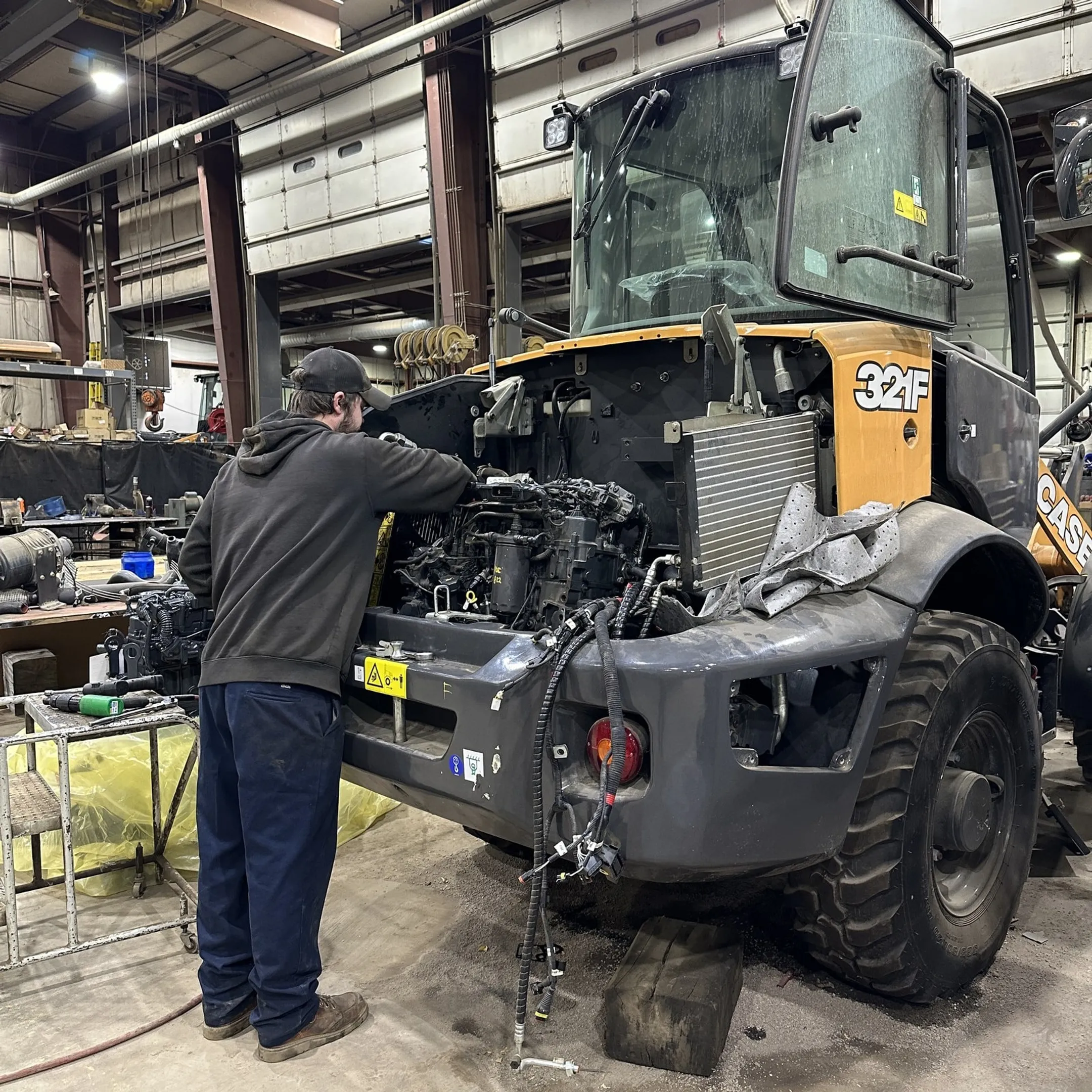 Technician repairing a diesel engine on heavy equipment