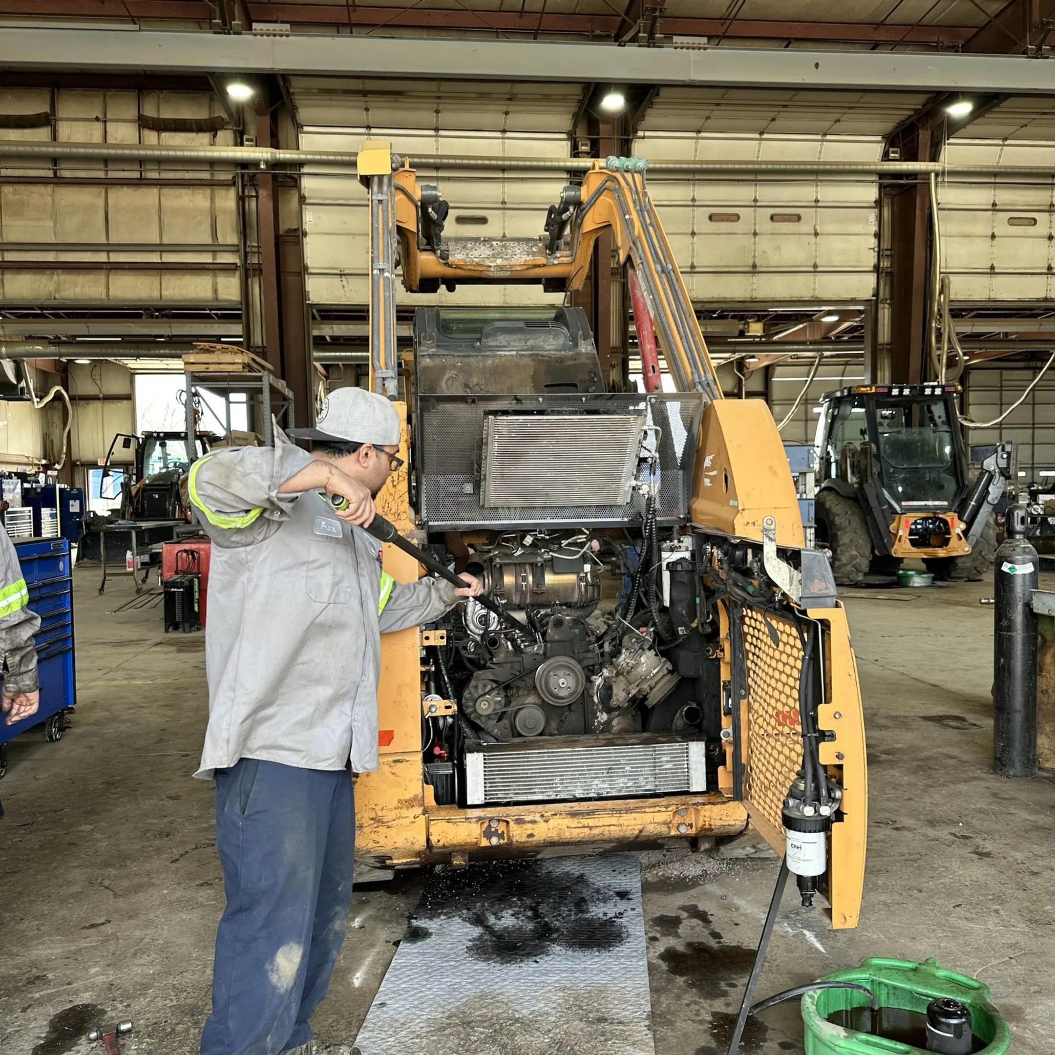 Technician diagnosing a construction equipment hydraulic pump