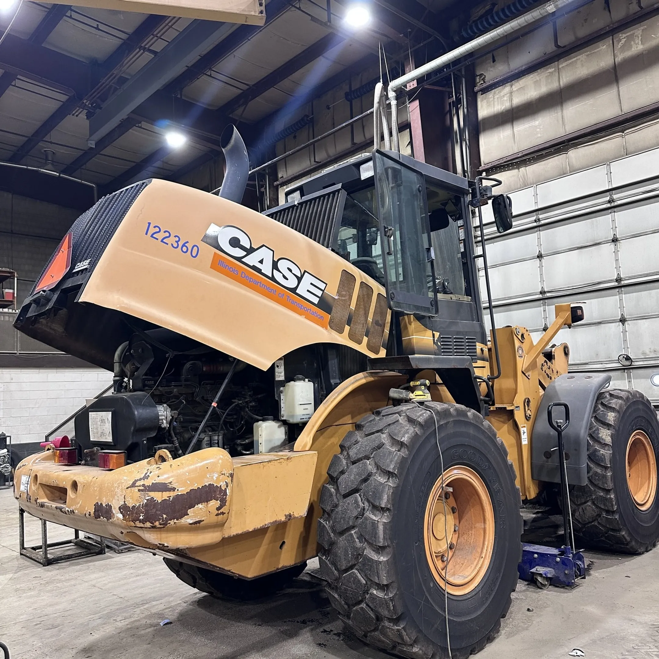 Mobile technician diagnosing heavy equipment engine at a jobsite