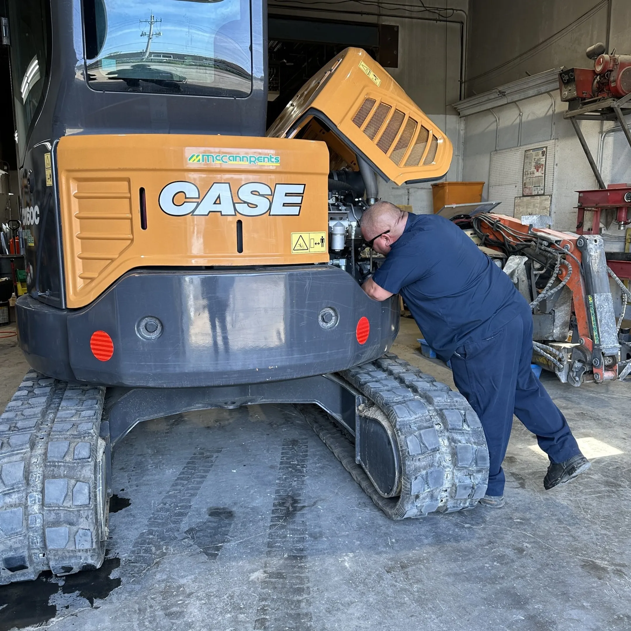 Technician servicing a mini excavator hydraulic system