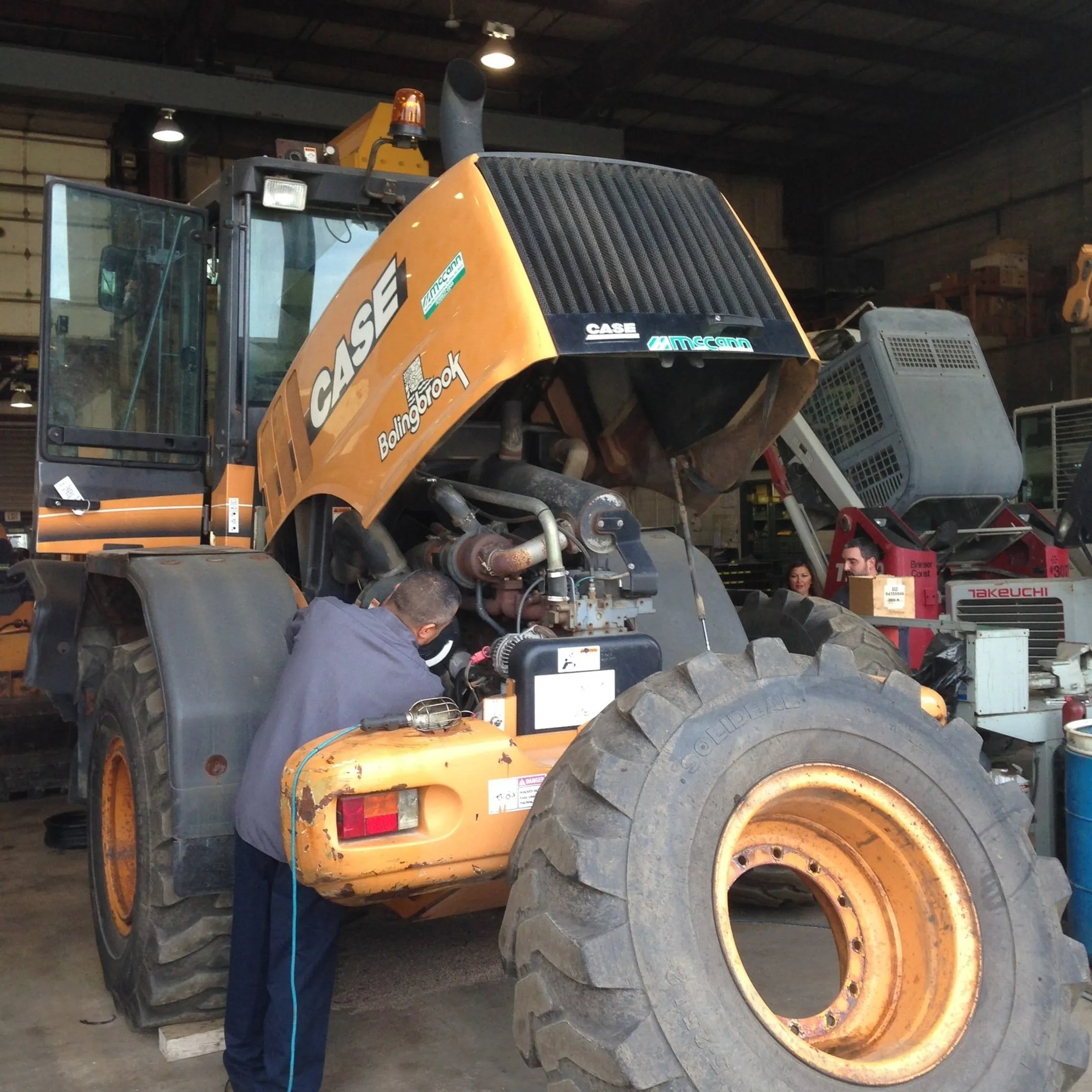 Technician diagnosing a construction machine engine
