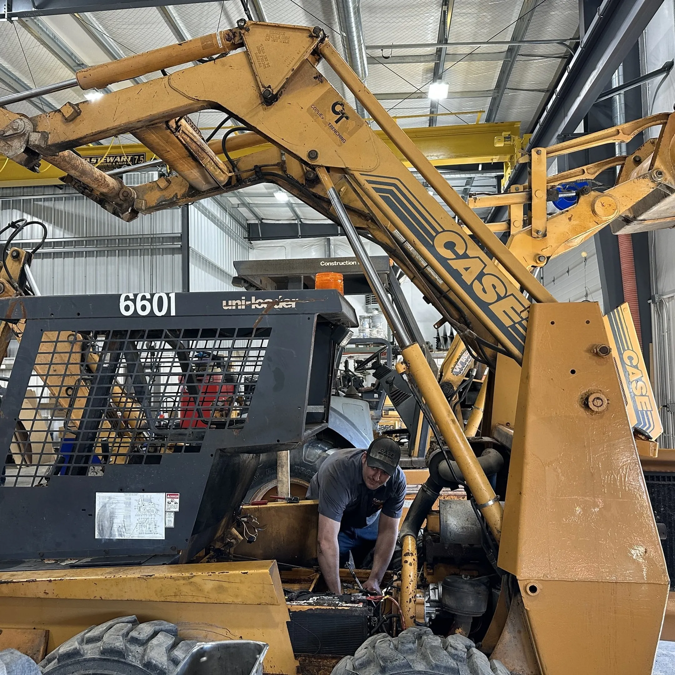 Technician diagnosing a hydraulic cylinder on construction equipment