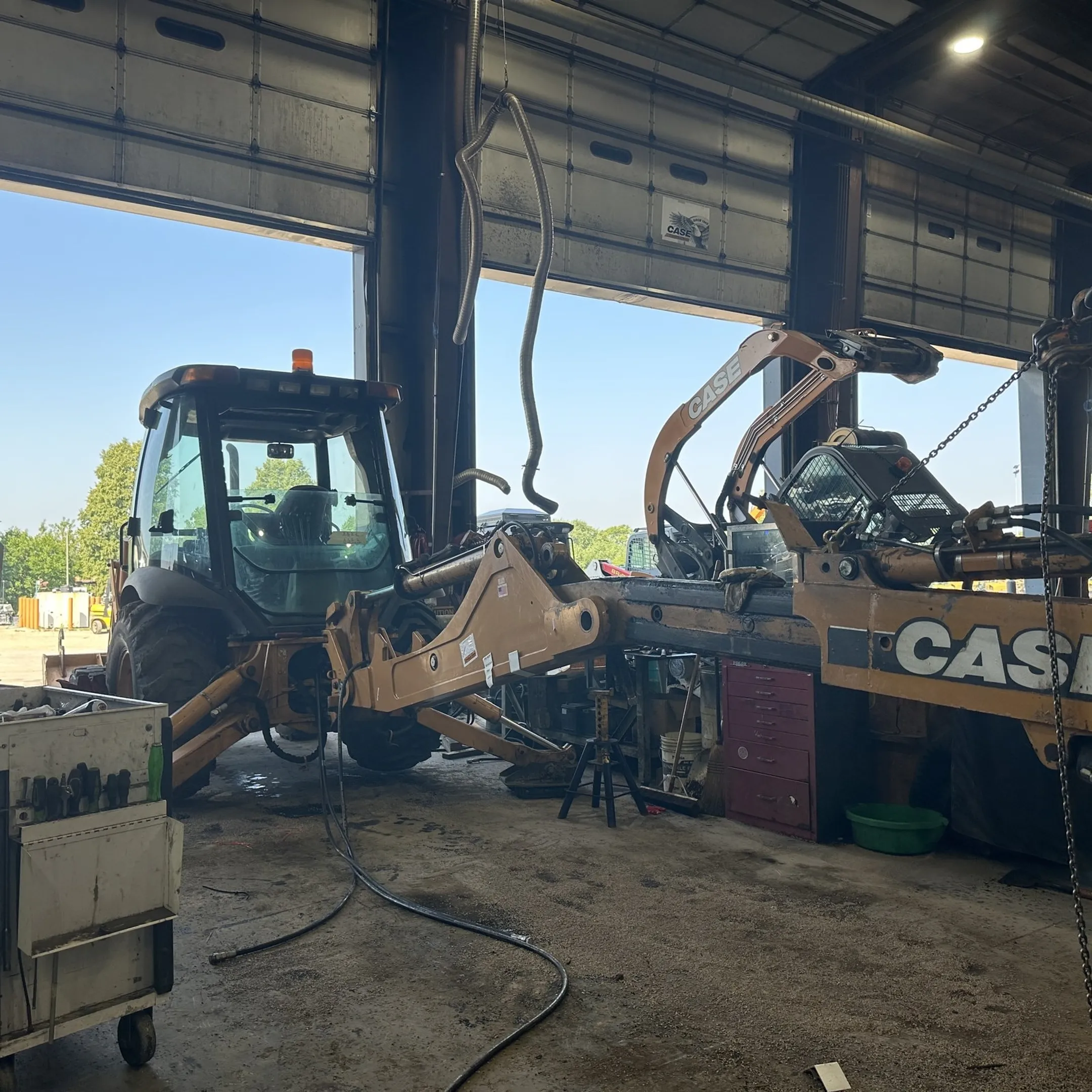 Technician servicing a backhoe hydraulic system