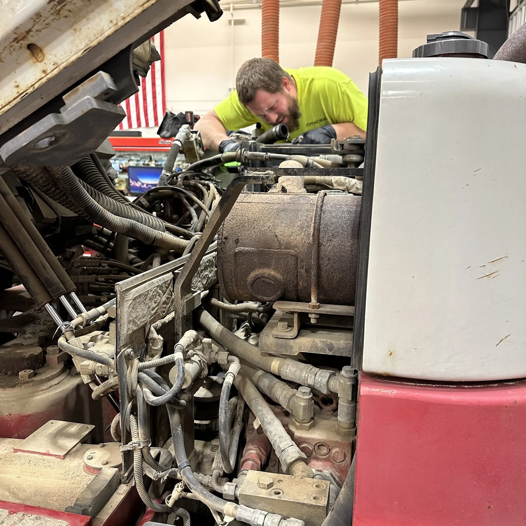 Technician repairing hydraulic components on construction equipment