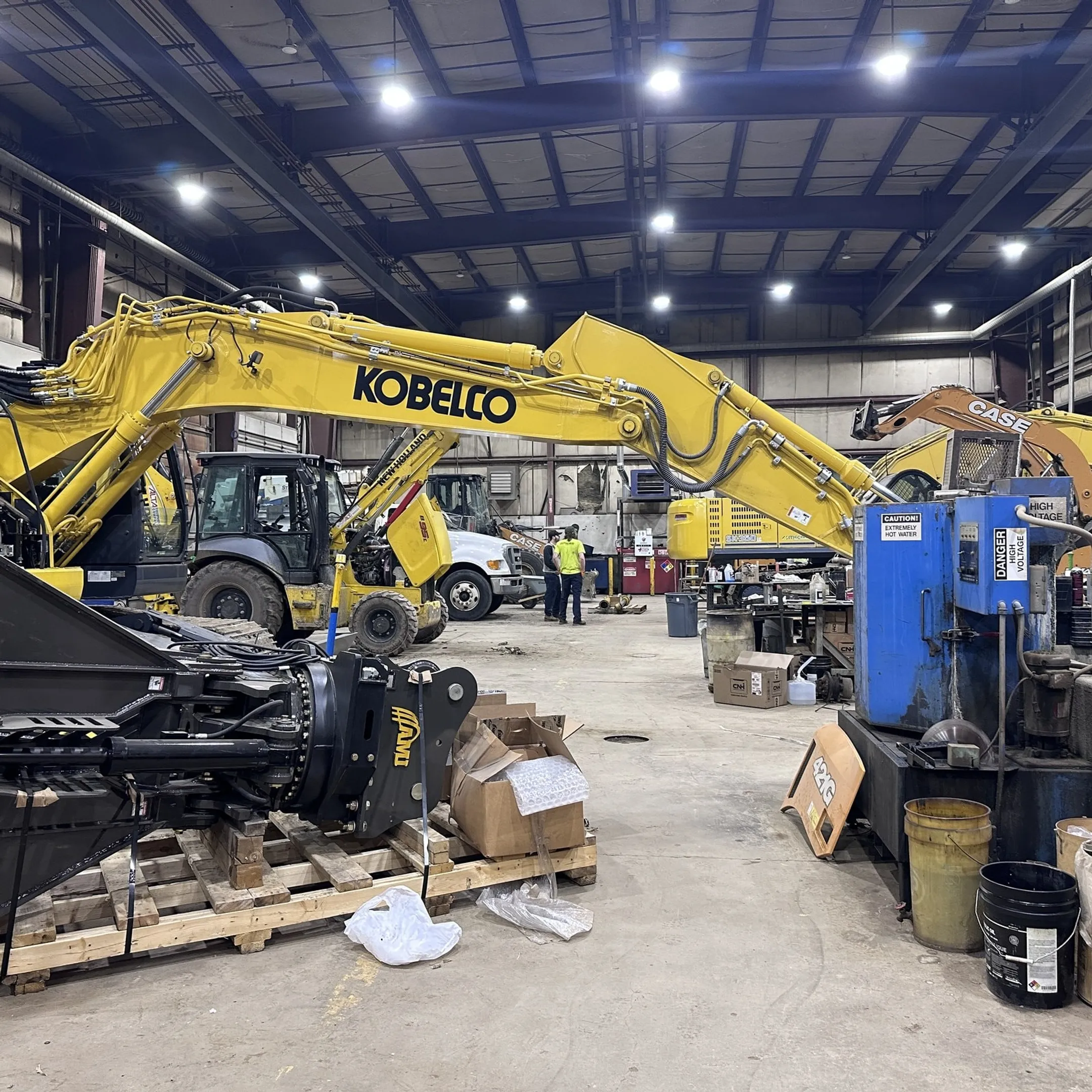 Technician repairing a hydraulic breaker with diagnostic equipment