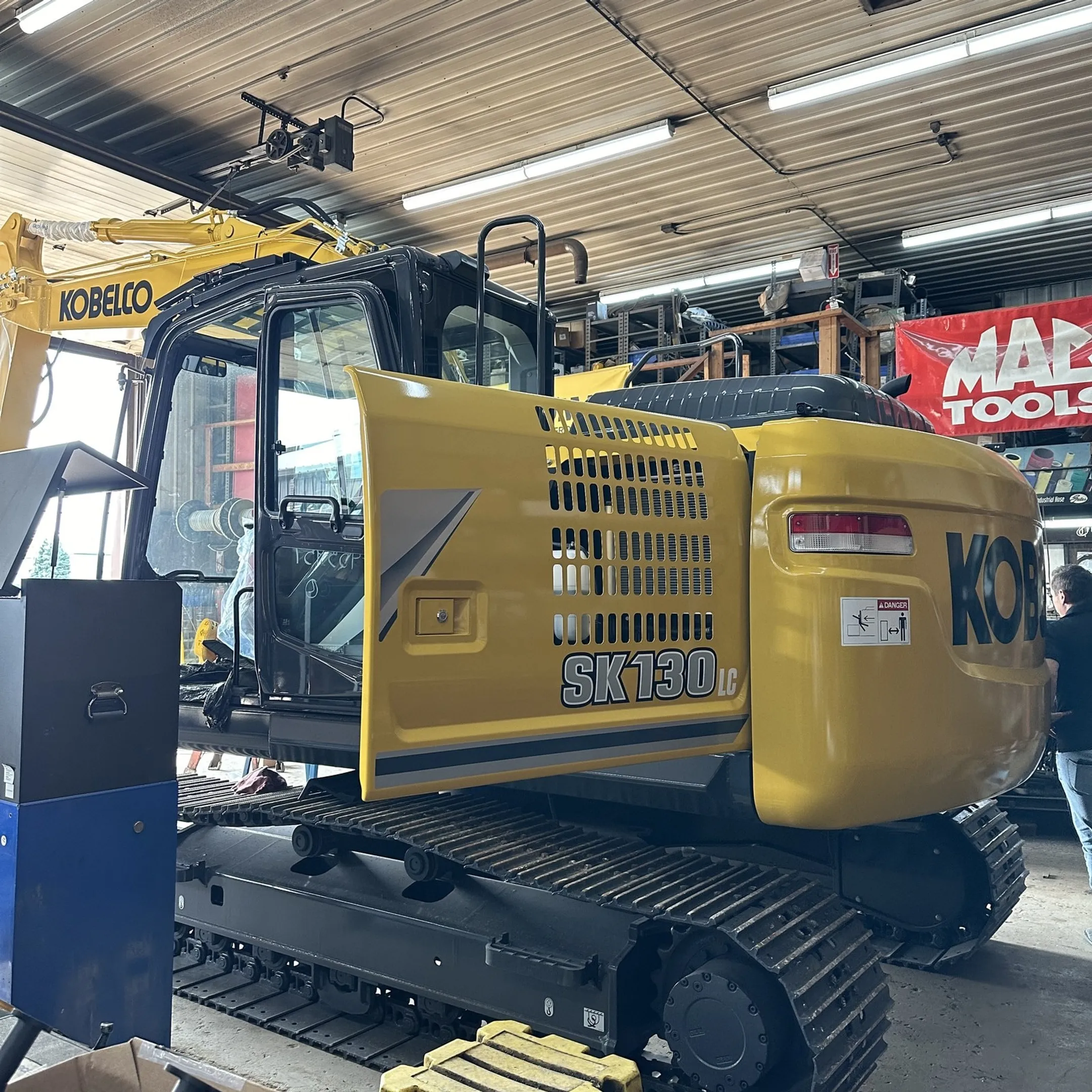 Technician diagnosing a hydraulic cylinder on construction equipment