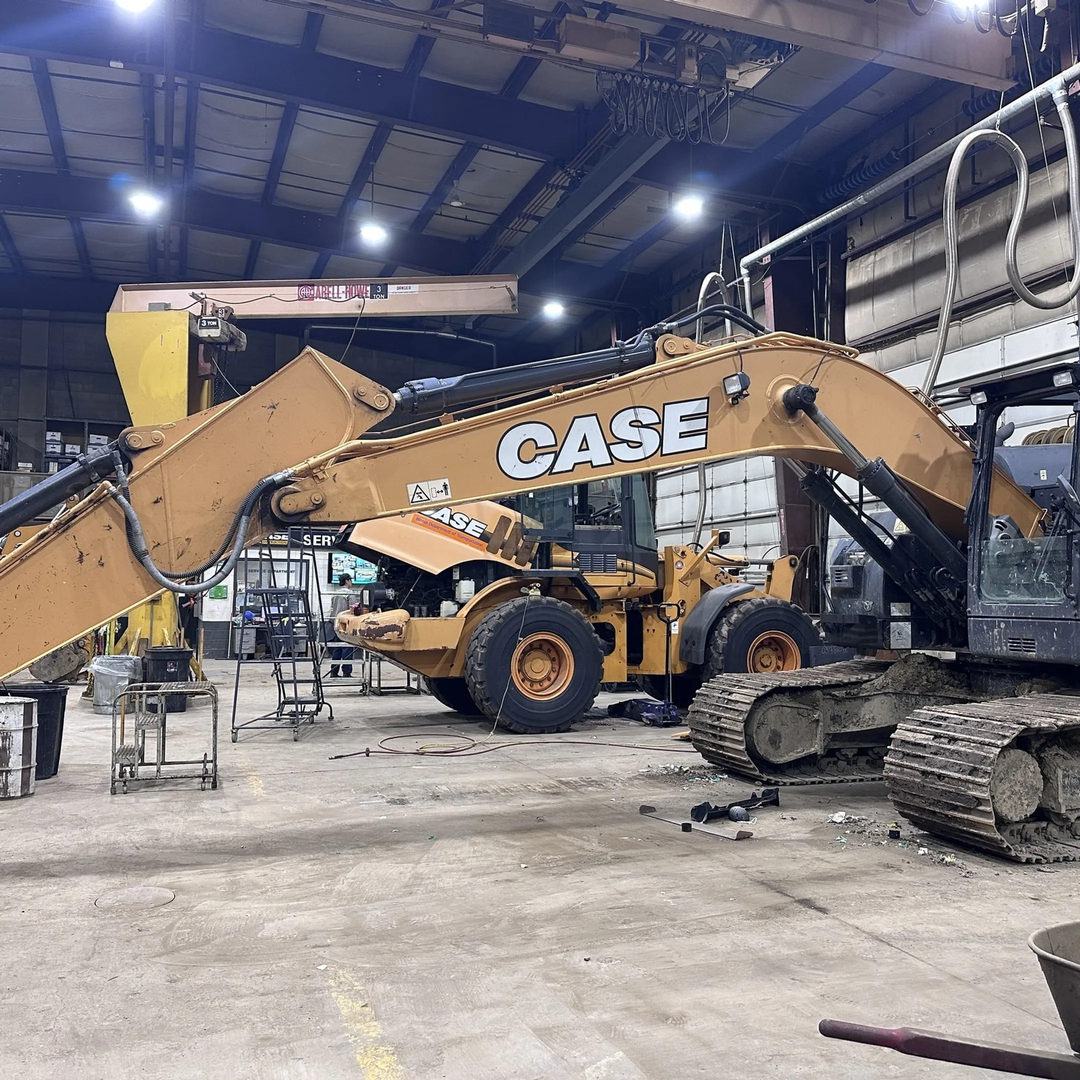 Technician diagnosing a hydraulic cylinder on heavy equipment